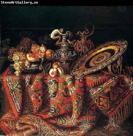 Jacques Hupin A still life of peaches, grapes and pomegranates in a pewter bowl, an ornate ormolu plate and ewers, all resting on a table draped with a carpet